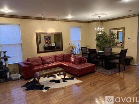 A living room with a red leather couch and a wooden coffee table.
