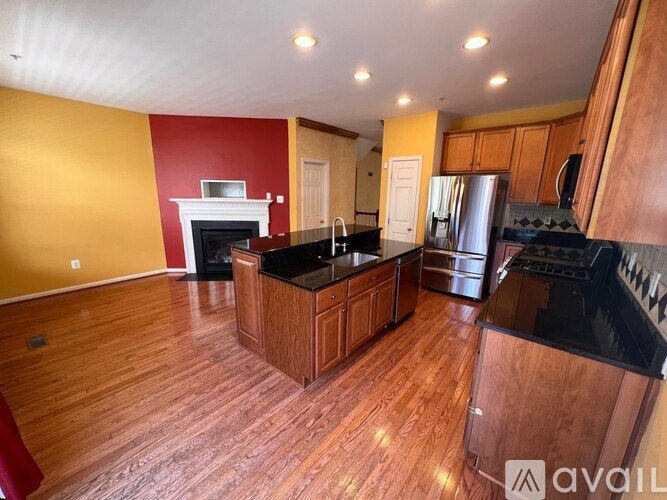A kitchen with wooden floors and a black countertop.