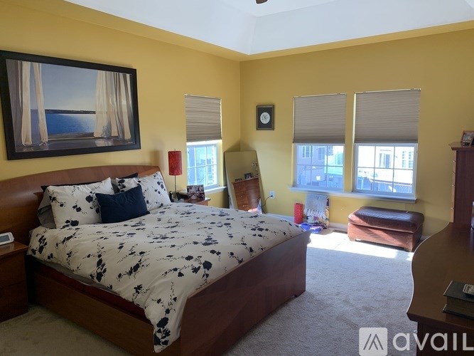 A bedroom with a bed, a chair, and a window.