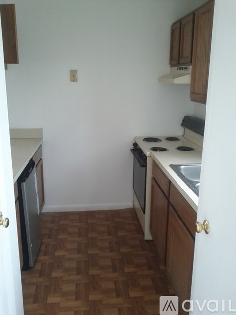 A kitchen with a white counter top and wooden cabinets.