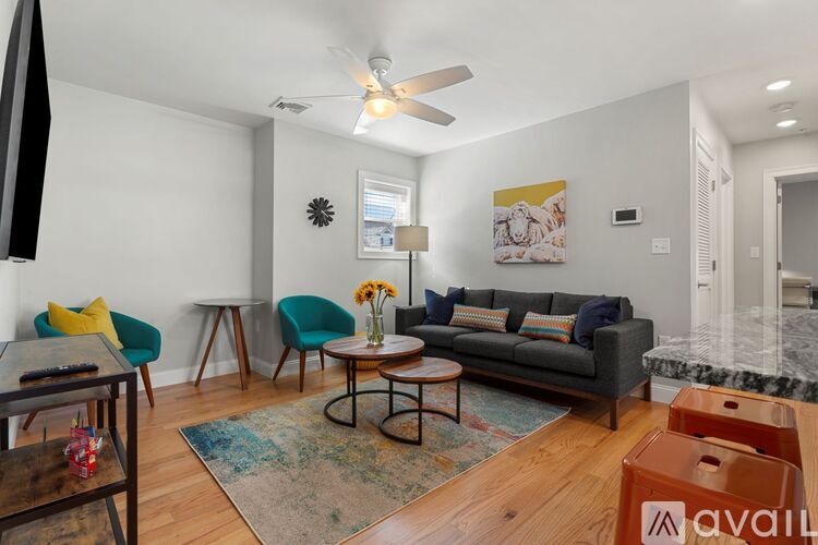 A living room with a grey couch, a coffee table, and a rug.