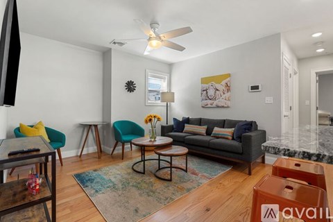 A living room with a grey couch, a coffee table, and a rug.