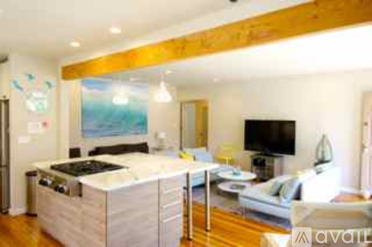 A modern kitchen with a wooden ceiling and a large island in the middle.