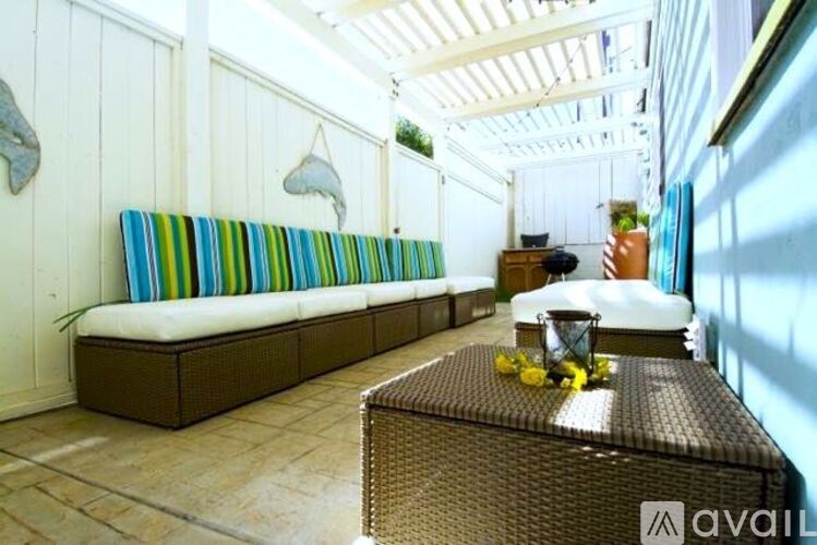 A sunny day in a patio with a sofa and a table.