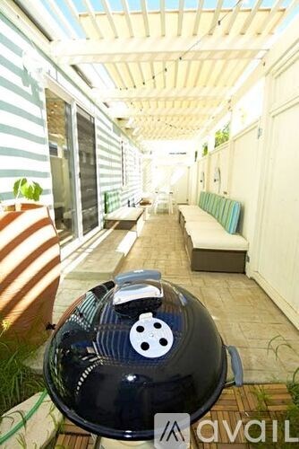 A black helmet with a white face is on a patio.