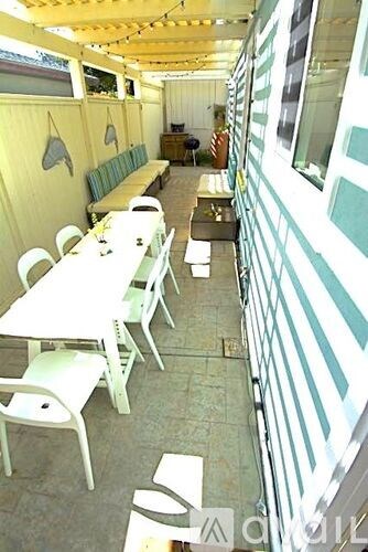 A white table with chairs is in front of a striped wall.