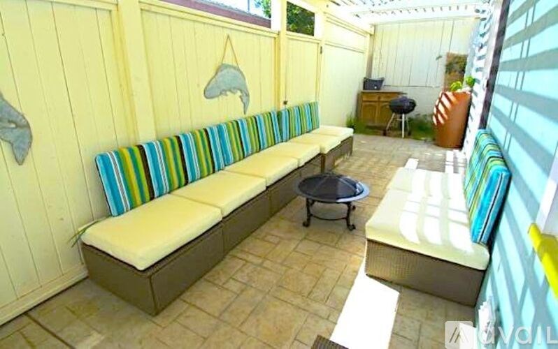 A yellow couch with a striped cushion is in the middle of a room.