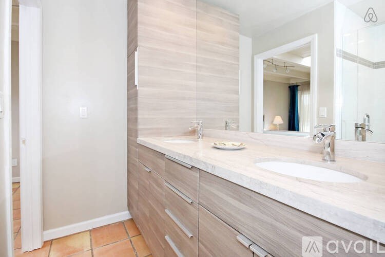 A bathroom with a sink, mirror, and wooden paneling.