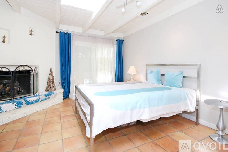 A bedroom with a large bed and a fireplace.