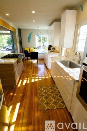 A kitchen with wooden floors and white appliances.