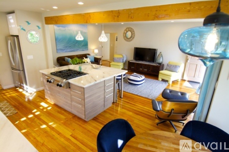 A living room with a white kitchen island and a brown couch.