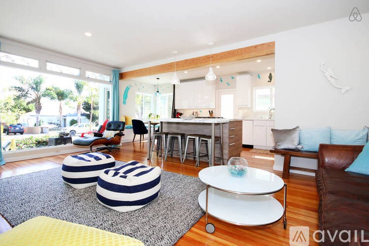 A living room with a white couch and a round white table.