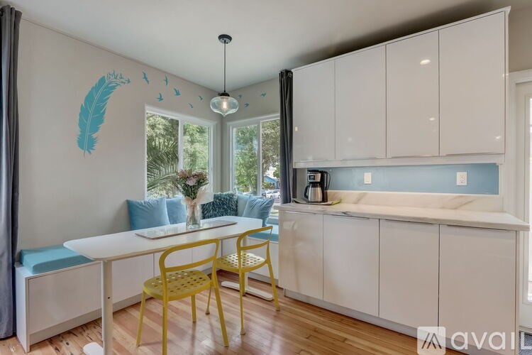 A dining area with a white table and yellow chairs.
