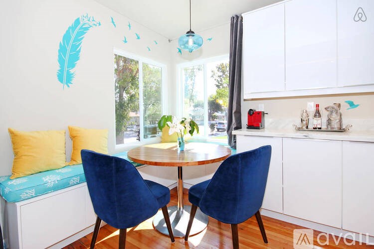 A kitchen with a table and two chairs.