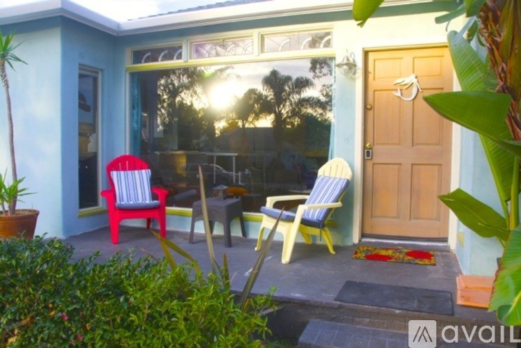 A patio with a red chair and a yellow chair is shown.