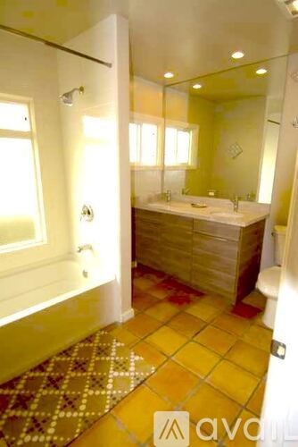 A bathroom with a tiled floor and a bathtub.