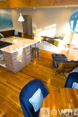 A living room with a blue chair and a wooden table.