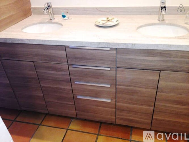 A bathroom with two sinks and wooden cabinets.