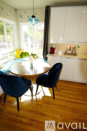 A kitchen with a table and chairs in the foreground and a window in the background.