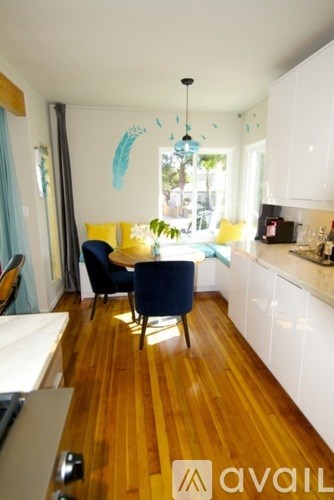 A kitchen with wooden floors and white cabinets.