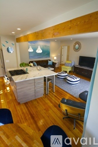 A living room with a couch, a bed, and a television.