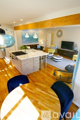 A living room with a wooden floor and a white sofa.