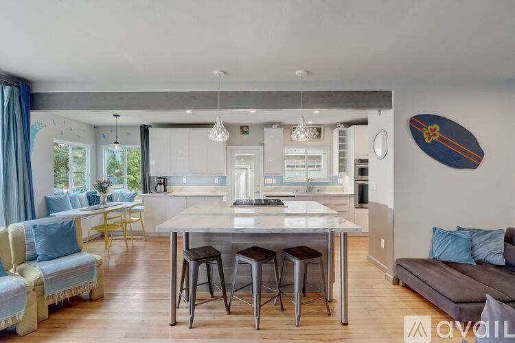 A modern kitchen with a large island and bar stools.