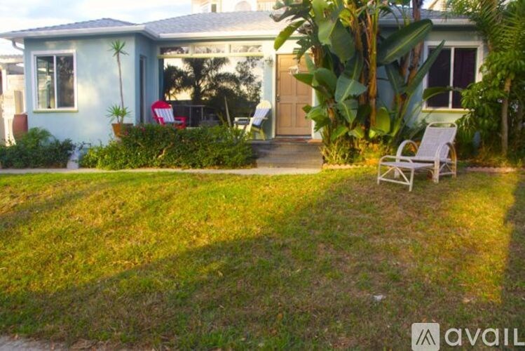A house with a blue door and a green lawn.