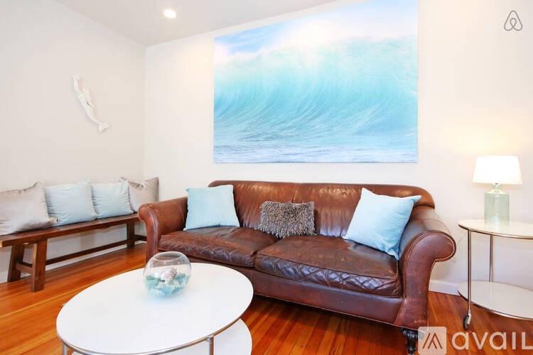 A living room with a brown leather couch and a white coffee table.
