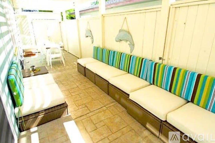 A white couch with a striped blanket is in the middle of a room.