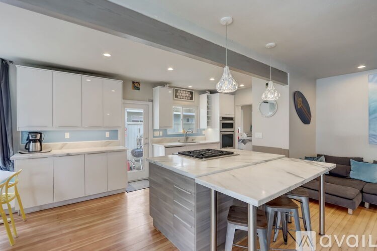 A modern kitchen with a large island and a dining area.