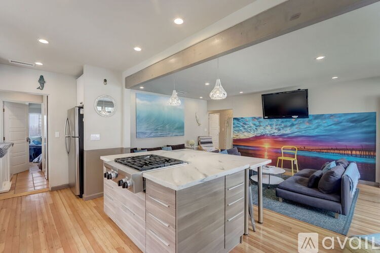 A modern kitchen with a wooden floor and a large island in the middle.