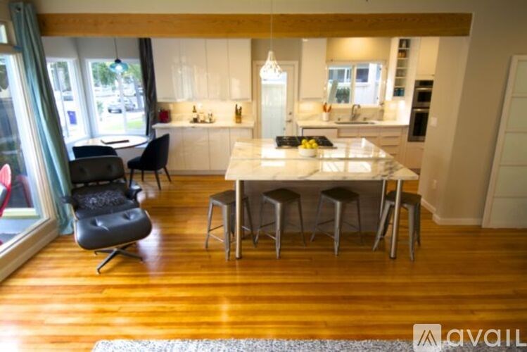 A kitchen with a table and chairs in front of a window.