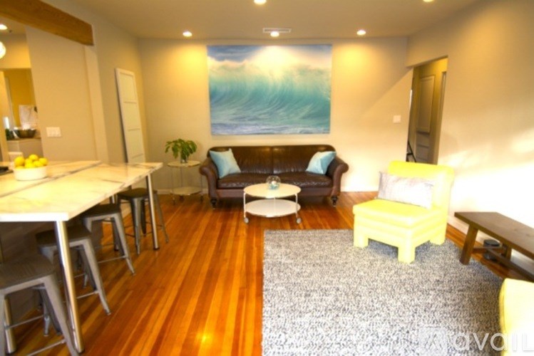 A living room with a couch, chairs, and a dining table.