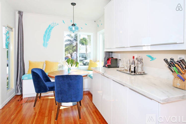 A kitchen with a blue chair and white cabinets.