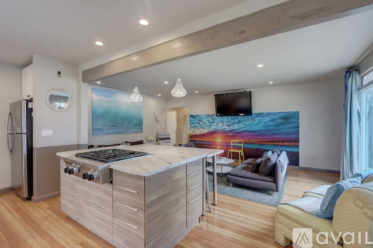 A modern kitchen with wooden floors and a large island.