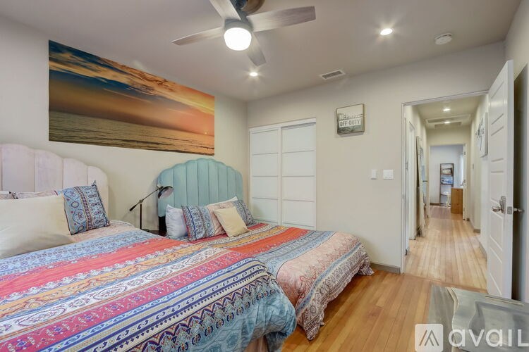 A bedroom with a large bed and a painting on the wall.