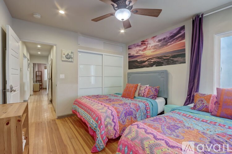 A bedroom with two beds and a ceiling fan.
