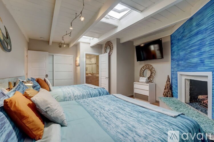 A bedroom with a bed, a fireplace, and a television.