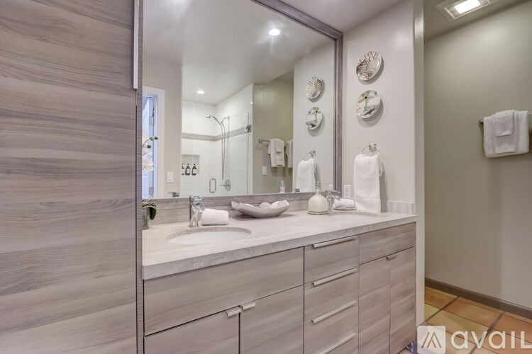A bathroom with a sink, mirror, and towel rack.