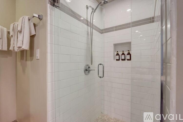 A bathroom with a shower and a towel rack.