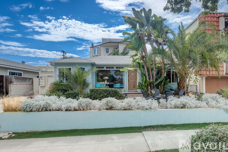 A house with a blue sky and clouds in the background.