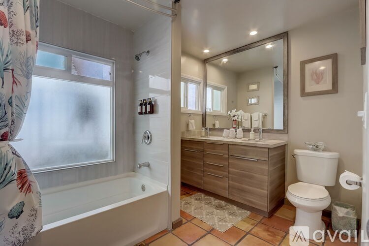 A bathroom with a tub, toilet, and sink.