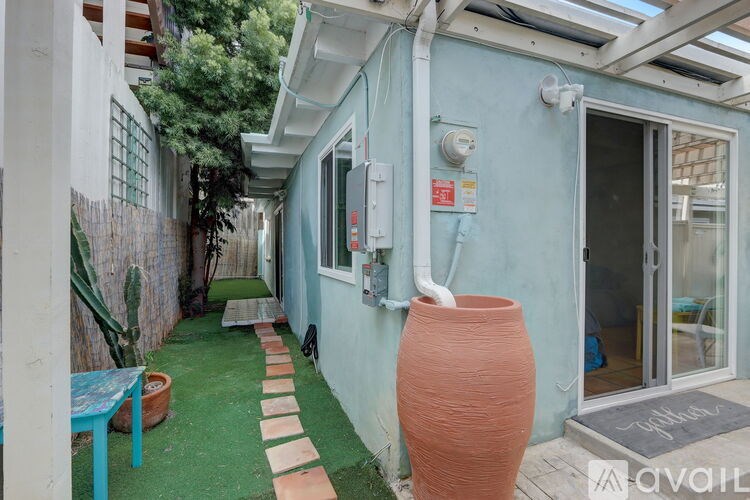 A blue house with a red vase in front.