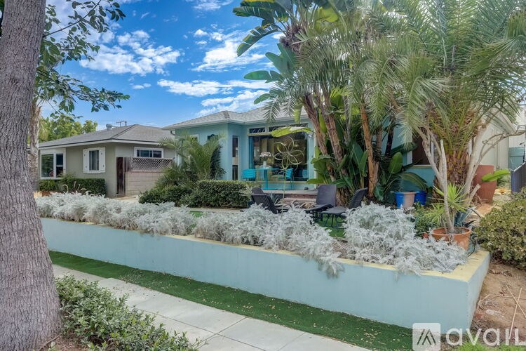 A house with a blue wall and a white fence.
