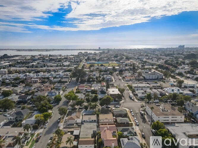 A bird's eye view of a residential area with houses, streets, and cars.