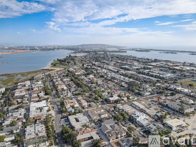 A bird's eye view of a residential area with a body of water in the background.