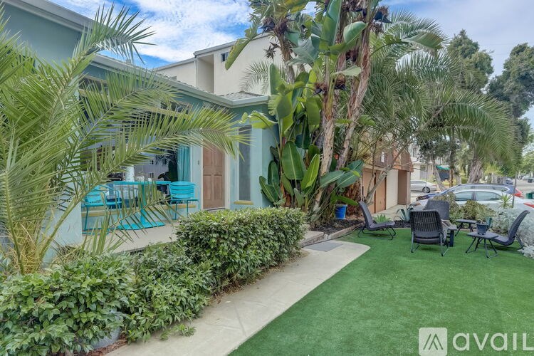 A well-maintained outdoor area with a lawn, chairs, and a variety of plants.