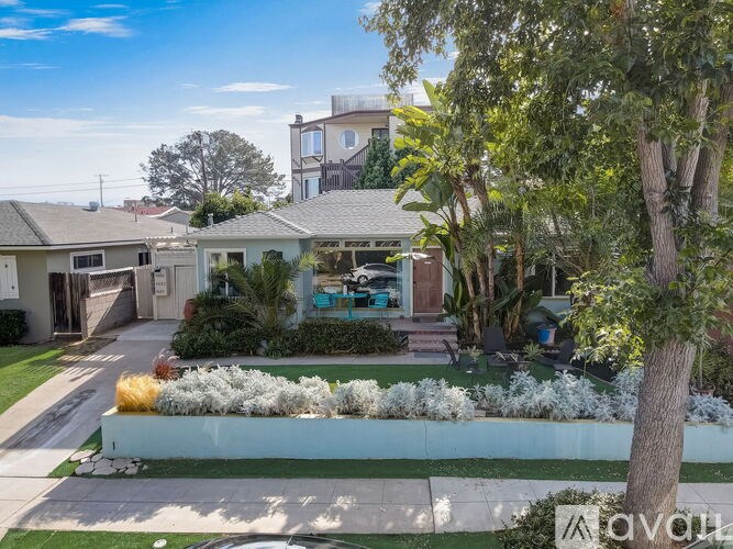 A house with a white fence and a garden in front.