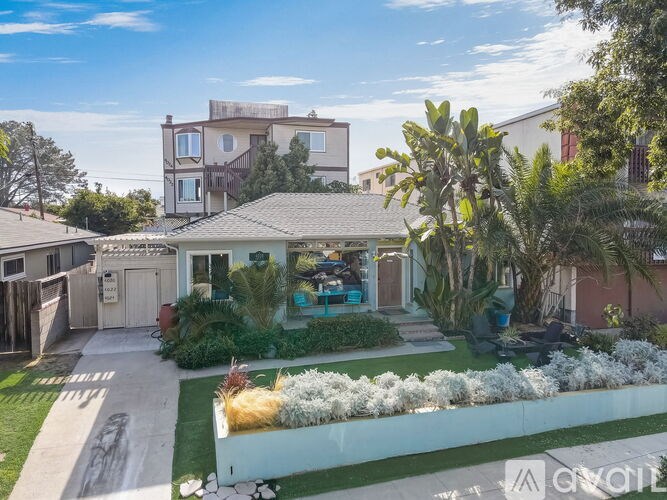 A house with a white fence and a green lawn.